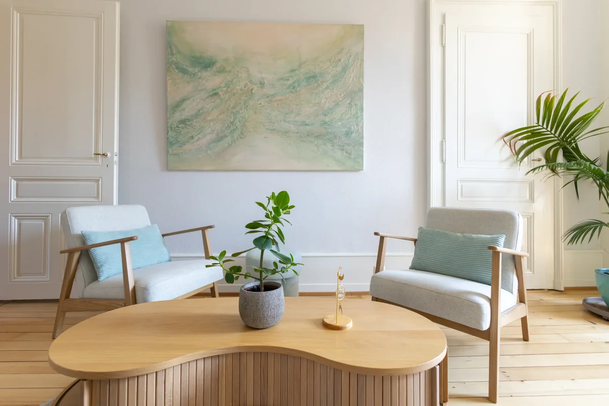 Trois fauteuils disposés autour d'une table dans une salle de consultation lumineuse
